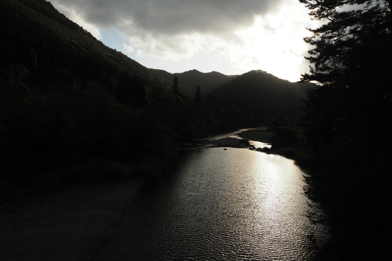 景勝地「抱返り渓谷」を歩きながら、秋の夕暮れが迫るひとときを広角端で捉える。川面と山並みに映える光の味わいも自然な描写で階調豊かに表現されている（撮影：高橋智史）。<br><span class="fnt-85">OLYMPUS OM-D E-M1 Mark II / M.ZUIKO DIGITAL ED 12-200mm F3.5-6.3 / 12mm（24mm相当） / 絞り優先AE（F8、1/1,250秒、-0.7EV） / ISO 400 / WB：オート</span>