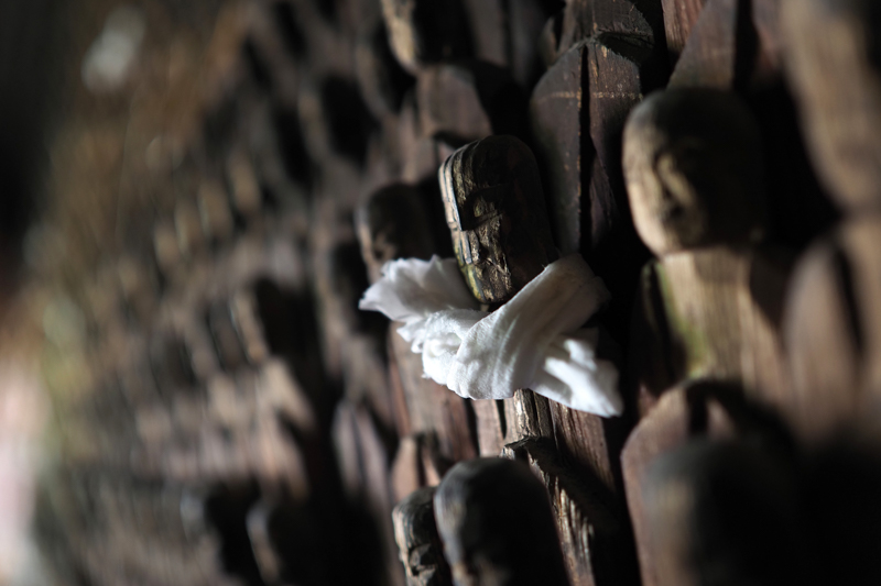 「真山の万体仏」。江戸中期の僧が、不幸な死を遂げた弟子と幼子を弔うために1万体以上の地蔵菩薩を彫った。その静ひつな空間を豊かなボケをいかして描写した（撮影：高橋智史）。<br><span class="fnt-85">OLYMPUS OM-D E-M1 Mark II / M.ZUIKO DIGITAL ED 17mm F1.2 PRO / 17mm（34mm相当） / 絞り優先AE（F1.2、1/30秒、-1.0EV） / ISO 200 / WB：オート</span>