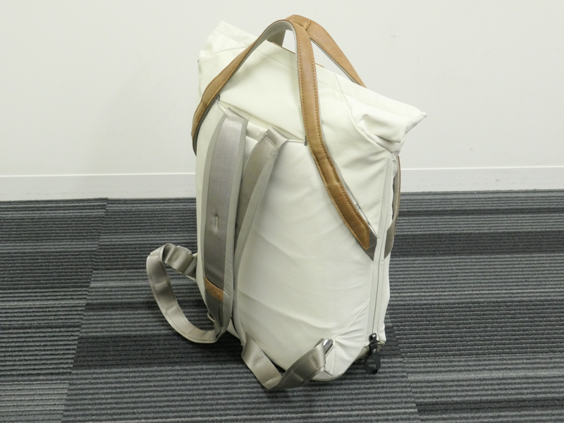 背面にバックパックストラップを装備。素材の柔らかさと、余ったストラップ部分が床に散らばらない仕組みが嬉しい。バッグ自体が薄めなため足下への収まりもよい。