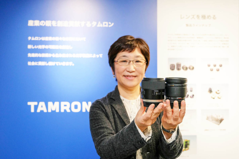 ショールームにて、初期の高倍率ズームと最新SPシリーズを持って