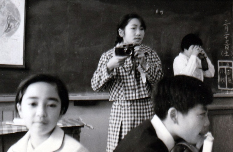 小学生の頃に教室でカメラを構える千代田さん