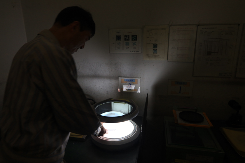 偏光板を通して結晶の内部検査を行う。