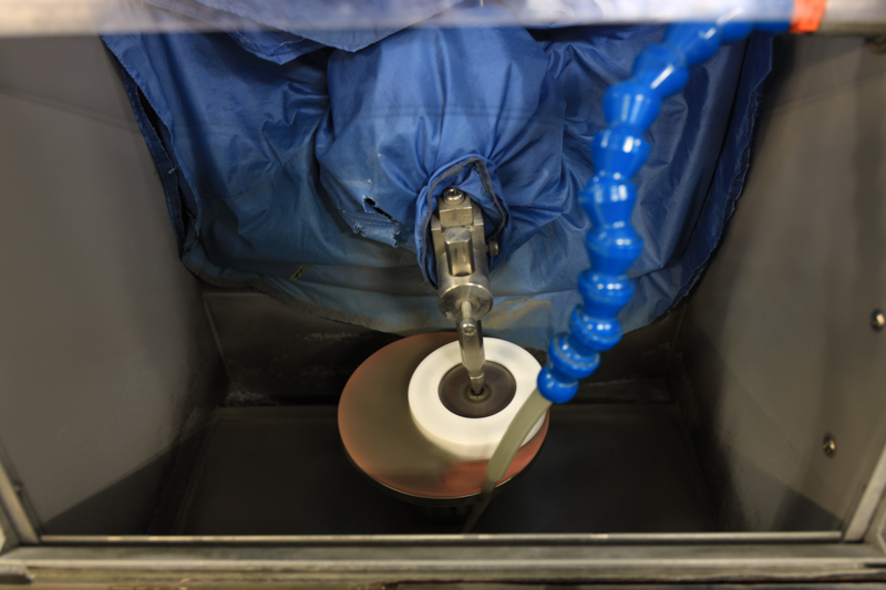 研磨加工。使用する水の量が多く、研磨剤の色も光学ガラスに用いられるものとは違っていた。この加工に蛍石は光学ガラスの2倍以上の時間がかかるのだという。採用が高級レンズに限られる理由が伺える。