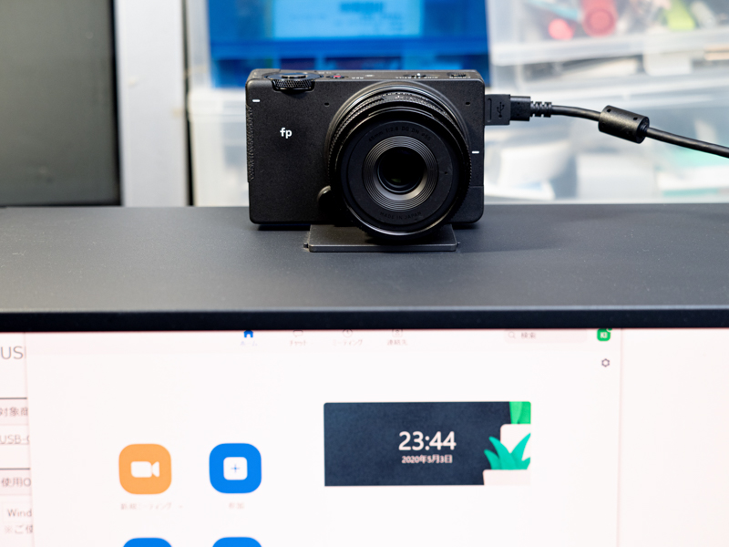 45mm F2.8 DG DN｜Contemporaryを装着したfp。小型軽量のレンズなので、試しにパソコンのディスプレイフードの上に仮置きしてみた。これだけでも"フルサイズセンサーのWebカメラ"という贅沢な配信環境を得られるのはちょっと驚き。