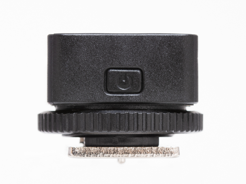 トランスミッター正面には電源ボタンを備える。電源がオンになると背面のランプが青く光る。