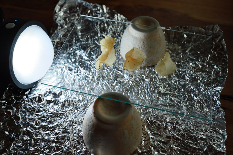 ・アクリル板：透明であれば厚さはなんでも良い。使わない額などに入っているものや、下敷きの透明なものがあればそれでも代用できる<br>・サランラップ：乱反射をさらにしやすくするためにクシャクシャに丸めたあと、アルミホイルの上に広げて敷く<br>・ライト：光源となる面があまり大きくないものを選ぶ（今回はプロフォトC1）。光を離し過ぎないよう、15cmくらいを目安にサイドに配置する