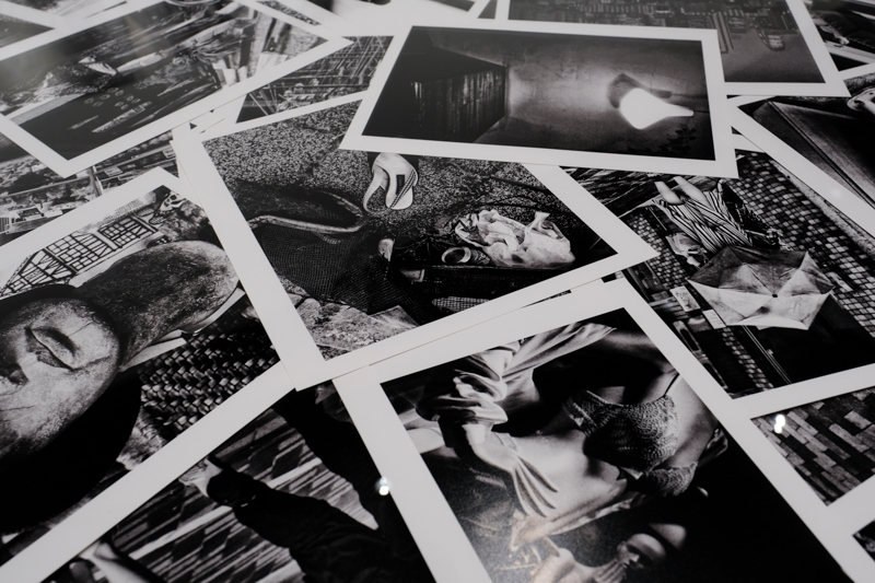 テーブル型の展示ケースの様子。大量のプリントが重なりあうようにして配置されている