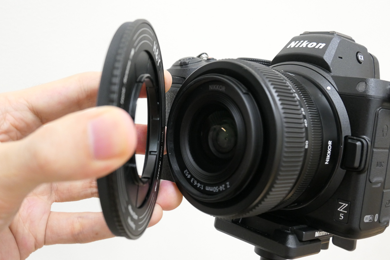 REVORINGをレンズ前面にあてがう。ネジ部分の突出量はレンズのフィルター取り付け部より浅いため、前玉に触れることはない。