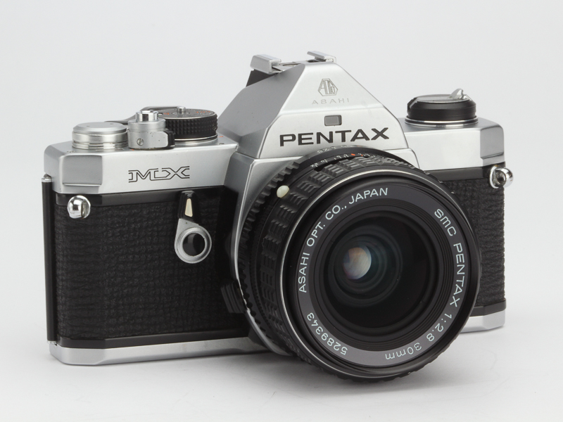 PENTAX MX。1976年発売。とにかく小さくていい。マイクロサイズ。オリンパスOM-1は背丈を低くするため、シャッターダイヤルをマウント基部にしたけど、こちらは普通のカメラと同様に上にある。
