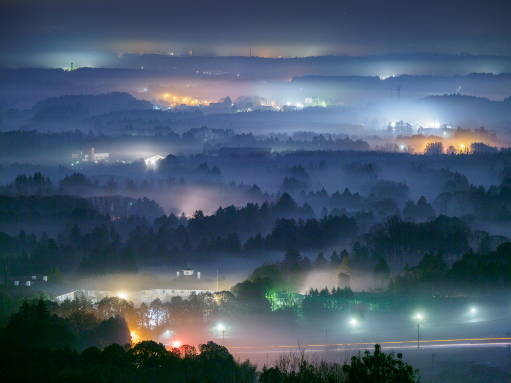 筑波山系の中腹にある三ツ石森林公園。夜明け前にライブタイム機能を使って長時間露光で撮影。背面モニターを確認しながら雲海と街明かりを狙った。<br><span class="fnt-85">OM-D E-M1 Mark III / M.ZUIKO DIGITAL ED 12-100mm F4.0 IS PRO / 92mm（184mm相当） / 絞り優先AE（F4、85秒、±0.0EV） / ISO 200 / WB:蛍光灯</span>