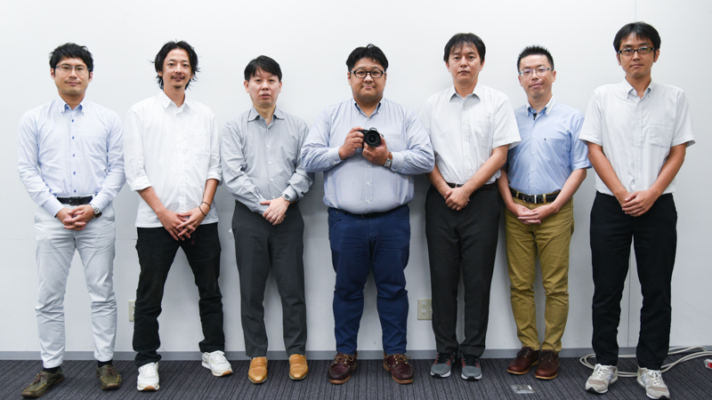 左から、映像事業部 開発統括部 第一開発部 第四開発課の神保直樹氏<br>映像事業部 デザインセンター IDグループの今水誠氏<br>映像事業部 UX企画部 UX企画二課の鈴木伸世士氏<br>映像事業部 UX企画部 UX企画一課の足立悠佑氏<br>映像事業部 開発統括部 設計部 第三設計課の森剛一郎氏<br>映像事業部 開発統括部 設計部 第一設計課の藤田昌之氏<br>映像事業部 開発統括部 第一開発設計部 第三開発課の浅見典充氏<br><span class="fnt-85">※ソーシャルディスタンスを考慮しておりますが、撮影時のみマスクを外しております。</span>