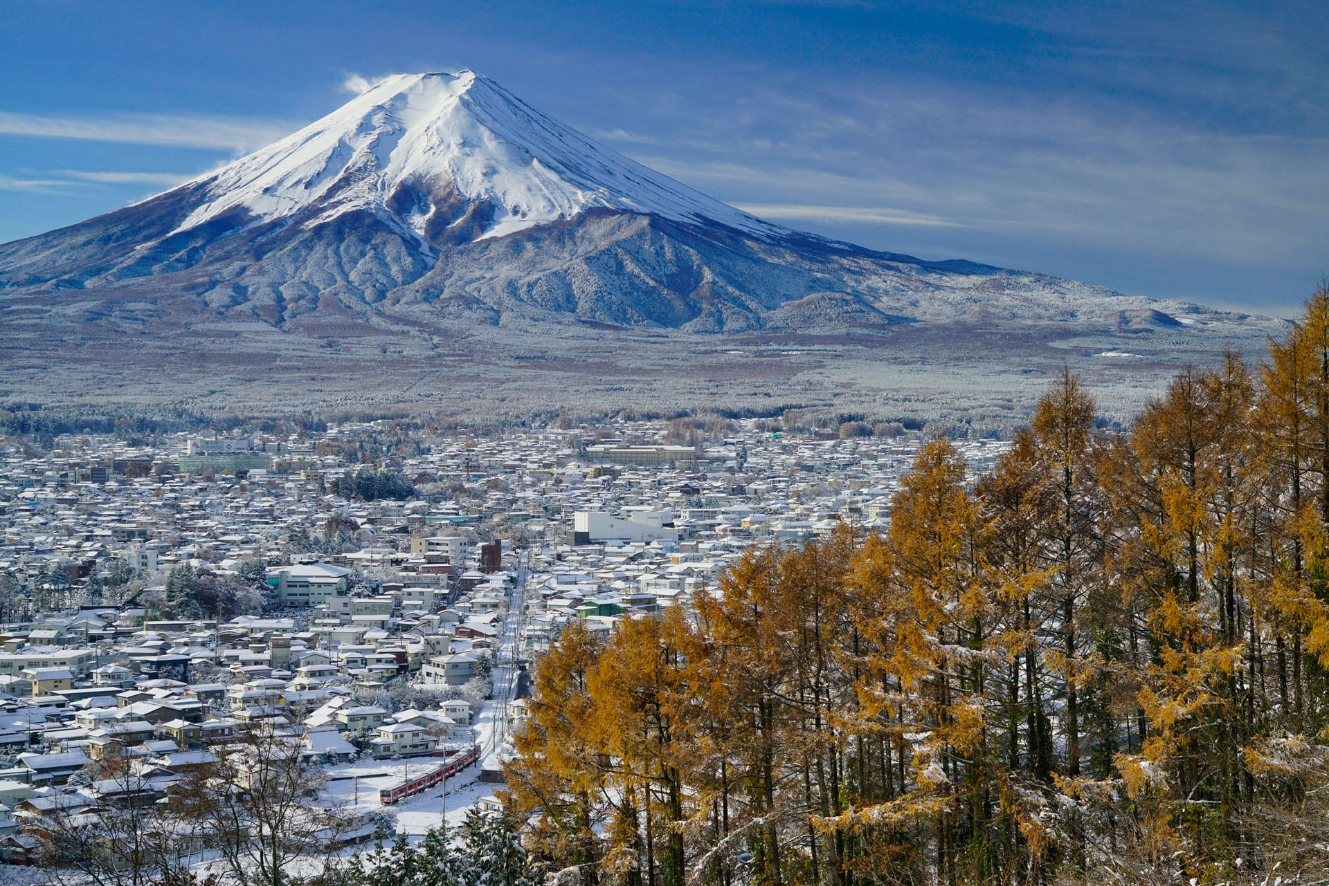 今回ご紹介するのは、富士山の絶景と富士急行を撮影できるポイント。この作品を撮ったのは、なんと11月。季節外れの大雪が降った朝に撮影したものです。勇壮な富士山と列車、そして紅葉がみごとにコラボレーションを見せてくれ、僕の代表作の一つになりました。眼下には富士吉田周辺の街が広がり、ギッシリと建物がありますが、奇跡的に列車のまわりだけ建物が少ないので、列車がちいさいながらも存在感を失うことなく撮れる貴重なポイントです。もし天気予報で大雪の翌日が晴れという予報が出ていたら、狙ってみてはいかがでしょう。<br>ソニーα7R II FE 24-70mm F4 ZA OSS(54mm) 絞り優先オート(F9、1/640秒)ISO 400 WB:太陽光