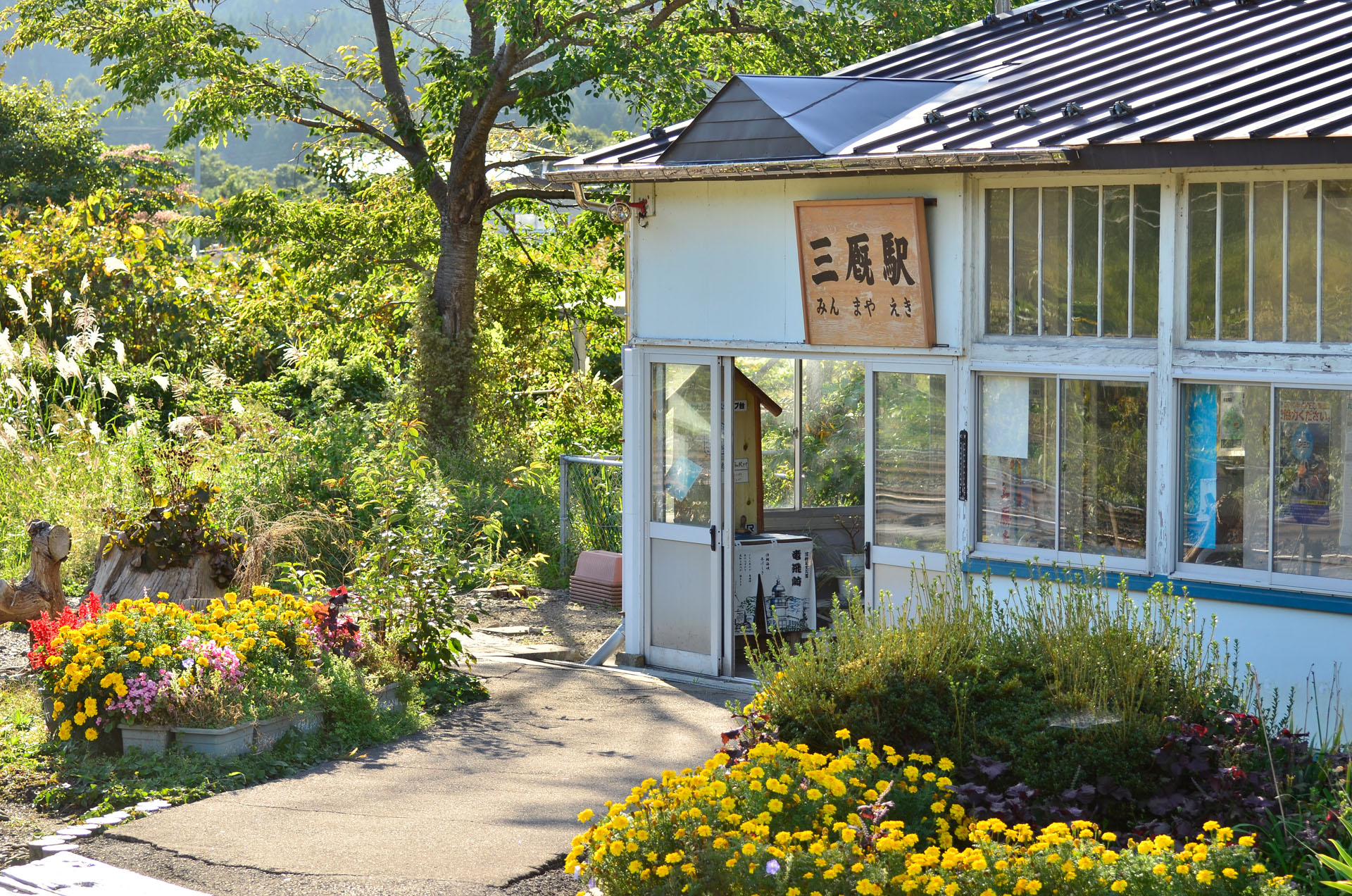 僕のオススメの撮影ポイントは、終着駅の旅情を堪能できる、津軽線の三厩（みんまや）駅です。三厩駅は津軽半島のほぼ先端に位置し、竜飛岬への観光の拠点ともなっていますが、市街地が駅から離れているため、駅の周囲は森につつまれとても絵になる駅なのです。日本にはたくさんの終着駅がありますが、ここまでイメージどおりの終着駅はなかなかありません。列車を降りると写真のようなかわいい駅舎が出迎えてくれます。どこか映画のワンシーンのようなこの駅は、きっと鉄道ファンじゃない人にとっても魅力的に映ること間違いないでしょう。<br>ニコンD7000　AF-S VR Zoom-Nikkor 70-300mm f/4.5-5.6G IF-ED（105mm）　絞り優先オート（F4.5、1/250秒）ISO 100　WB:曇天　スタンダード　<a href="https://goo.gl/maps/dQUgJ198a3jSxVj56" class="n" target="_blank">[GoogleMaps]</a>