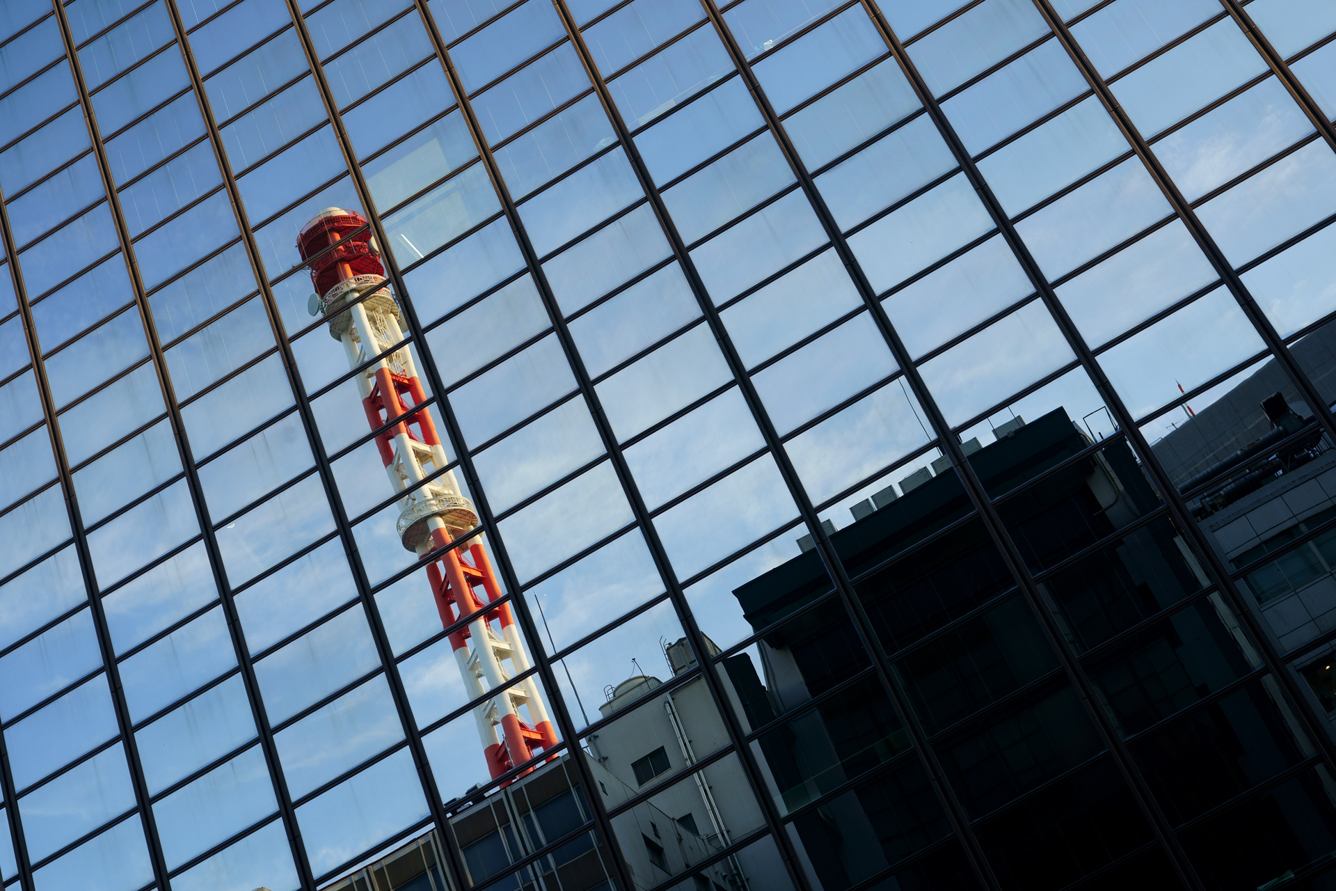 窓に映るリフレクションを利用した都市風景。微妙な歪みを利用しようという考え方。しかし、鏡面に映る像以外はとても素直でよい感じですね。<br>α7C　FE 28-60mm F4-5.6（F6.3・1/80秒）ISO 100　60mm