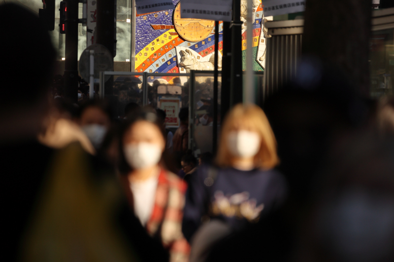 ハチ公の壁画と手前の通行人に光が当たったタイミングを狙い、手持ちでフットワーク良くシャッターを切ることができた。ぼけているがマスクをしている女性たちから「今」がうかがえる（撮影・キャプション：鶴巻育子）<br><font color=gray><span class="fnt-85">EOS R6 / RF600mm F11 IS STM / 600mm / 絞り優先AE（F11・1/660秒・-0.3EV） / ISO 1600 / WB:日陰</font></span>