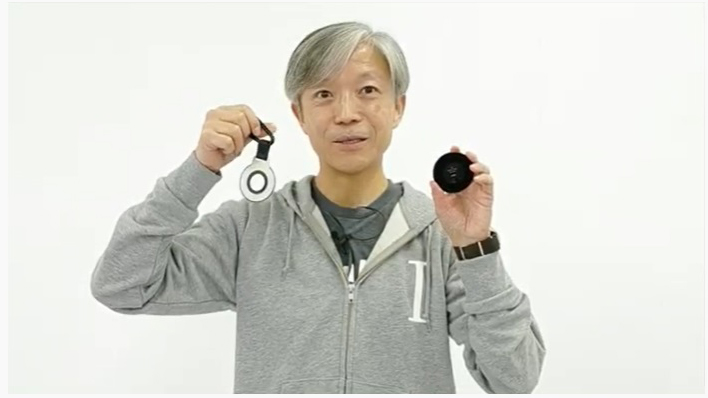 マグネット式メタルキャップとレンズキャップホルダーを持つ山木氏。