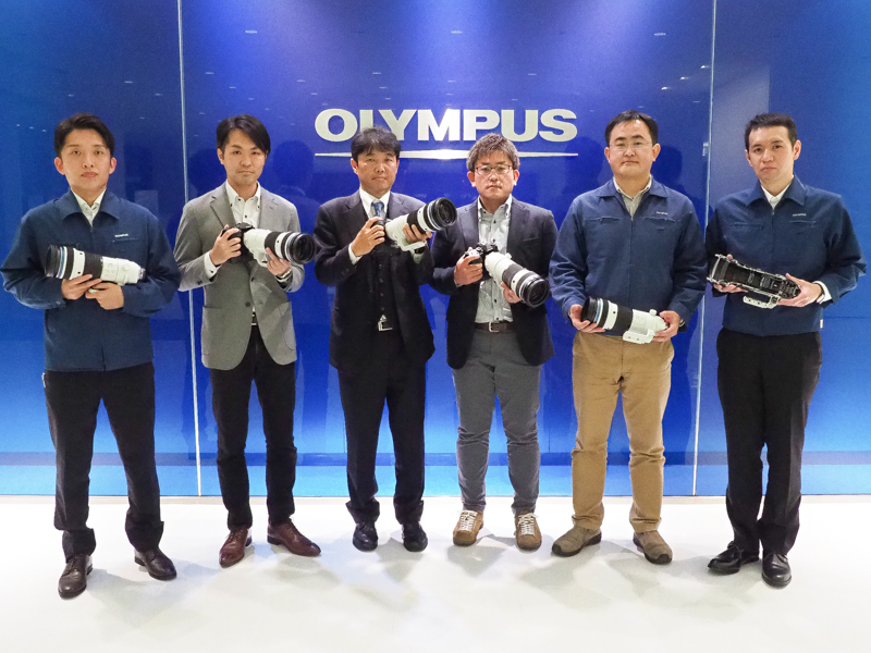 左から、メカ制御技術 開発1 堀内円嘉氏（手ぶれ補正担当）<br>映像商品企画 商品企画1 小野憲司氏（商品企画担当）<br>映像事業 副事業長 片岡摂哉氏<br>映像開発 レンズ製品開発 開発1 村山恭二氏（プロダクトリーダー）<br>映像開発 レンズ製品開発 開発1 スーパーバイザー 安富暁氏（メカ設計担当）<br>光学システム開発 映像光学開発 開発1 窪田勇樹氏（光学設計担当）