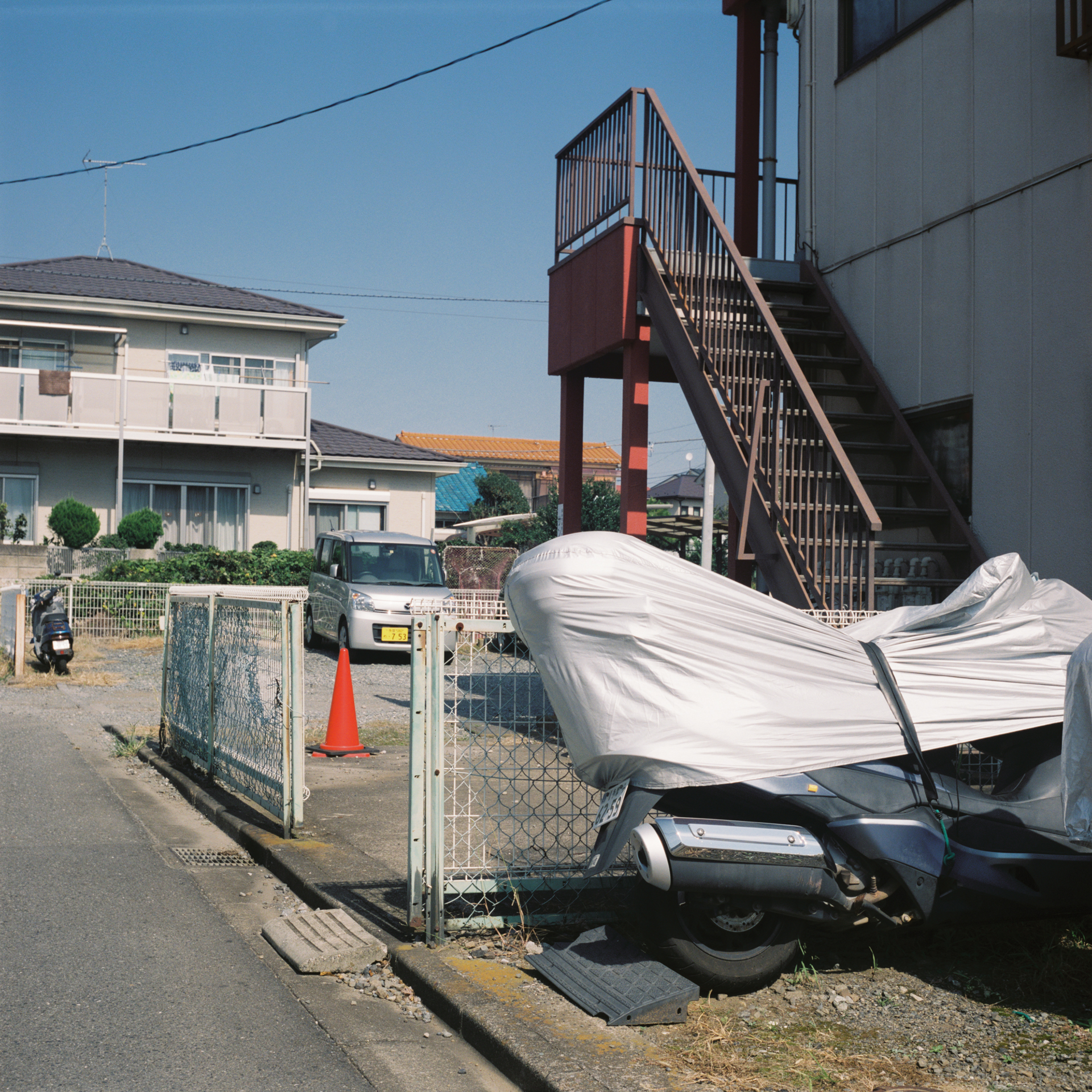 このような名機で、なんでもない道端の風景とか撮影して人に見せちゃいけないのかもしれませんが、本作品は被写体の意味や魅力だけには頼らないこともひとつのテーマにしています。<br>ローライフレックス3.5F　プラナー75mm F3.5（F11・1/500秒）フジカラープロ400H