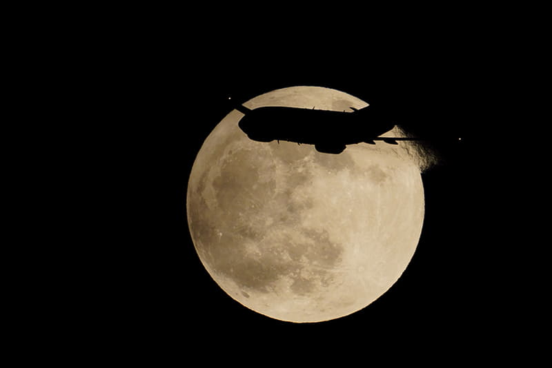 11月30日に見られた半影月食の状態で上がってきた満月。左上側が薄っすらと暗いのが判る。高感度時のノイズは気になるが、FE 200-600mm F5.6-6.3 G OSSと2倍テレコンの組み合わせでもシングルAFは効くので、そのコンパクトさもあって超々望遠ながら利便性は高い。 <br>SONYα7RⅣ / FE 200-600mm F5.6-6.3 G OSS＋SEL20TC / 1,200mm（APS-Cクロップ・1,800mm相当） / マニュアル露出（F13・1/1,600秒） / ISO 2500