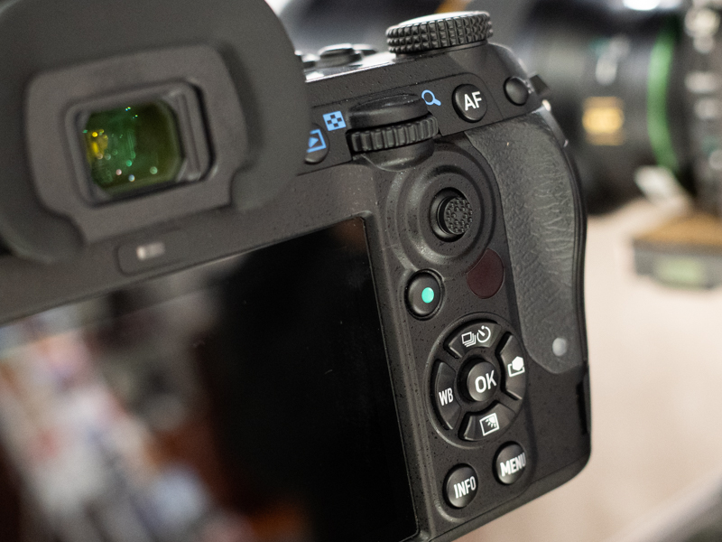 背面に測距点選択用のジョイスティックが追加。従来はOKボタン周囲の方向キーをショートカットキーと共用していたが、独立して扱えるようになった。