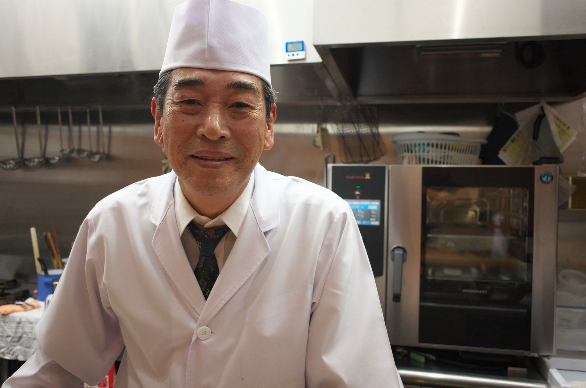 料理人。光線状態は良くないですが、ストロボは使いませんでした。顔認識機構により酔っ払いさんでもちゃんと写せました。<br>COOLPIX A（F4.0・1/200秒）ISO 800