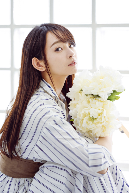 ガラス越しの柔らかな光が女性をたおやかに見せてくれる。白い花や白い服も白飛びしない階調再現は見事だ<br><span class="fnt-85">Nikon Z 7II / NIKKOR Z 85mm f/1.8 S / 85mm / マニュアル露出（F1.8、1/160秒） / ISO 200/ WB:オート</span>