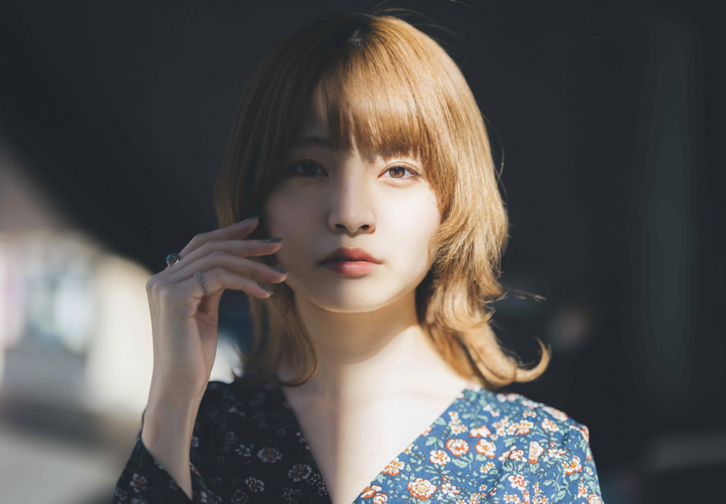 ビルとビルの間から光が差し込む中に見え隠れする女性の瞳の存在感を追求した。背景がとろけるようにぼける一方で、瞳は繊細に描かれ、画面に美しく浮かび上がった（撮影・キャプション：飯野匠紀）<br><span class="fnt-85">Nikon Z 7II/ NIKKOR Z 50mm f/1.2 S /マニュアル露出（F1.2、1/6,400秒） / ISO 125</span>