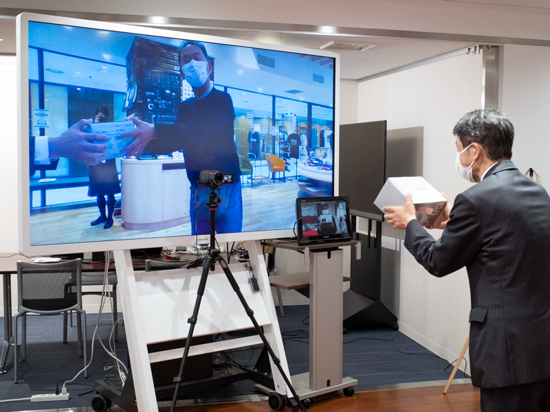 オンラインでも手渡し。大阪の購入者と同じカラーの外箱を手にとる、社長のこだわり。