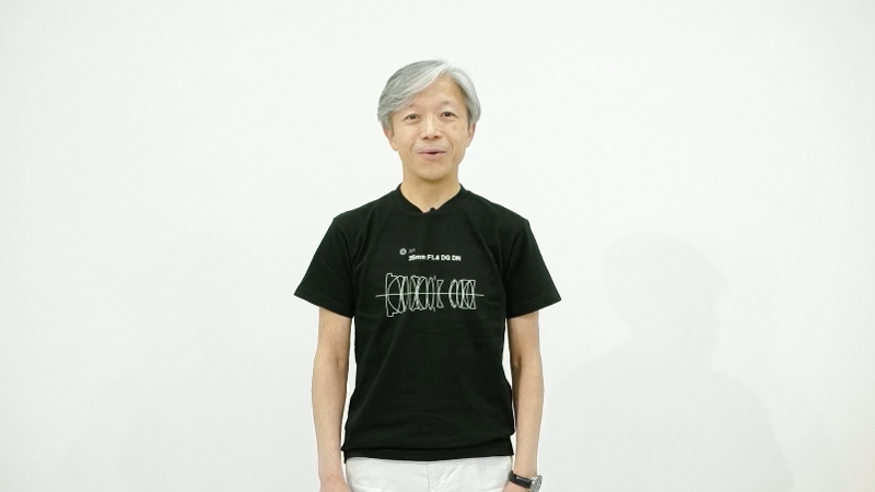 株式会社シグマ代表取締役社長の山木和人氏。着用している新レンズTシャツは5月21日に税込2,750円で発売。