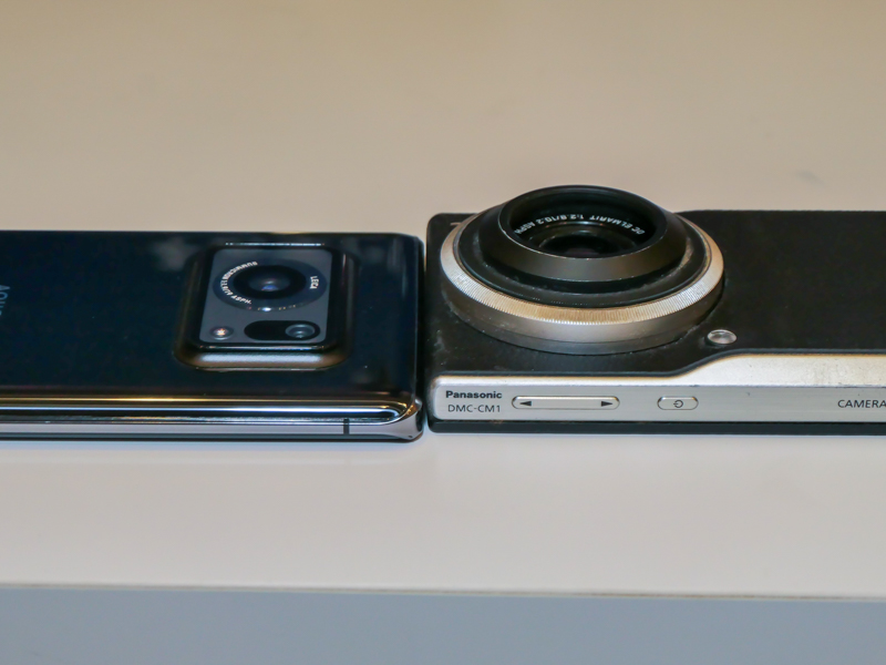 参考：AQUOS R6とLUMIX CM1（※社外品のフジツボ型フードを装着）の比較。LUMIX CM1はレンズが大きく、沈胴式のため、同じ1インチと考えれば、AQUOS R6は大幅に薄型化している