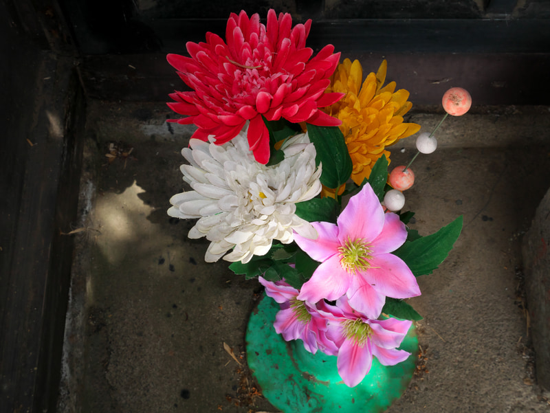 道端の祠にあった造花を内蔵フラッシュを使って撮りました。フラッシュの使用は初めてです。露出や自然光のバランスも良いですが、これは偶然です。おそらくこれが最初で最後の使用になるでしょう。<br>LUMIX DMC-GM1　LUMIX G VARIO 12-32mm/F3.5-5.6 ASPH./MEGA O.I.S.（F11・1/50秒）ISO 400