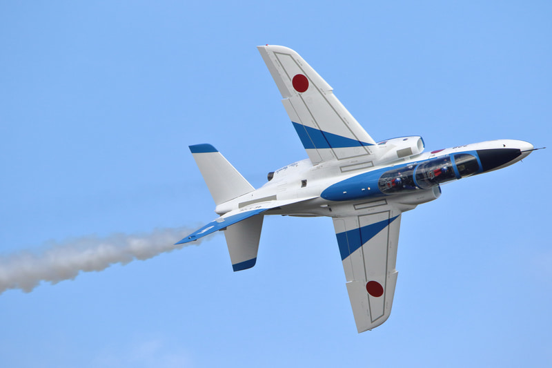 航空祭では展示飛行の高度が低いため、機体を回転させるアクロバット飛行を望遠レンズで狙うと、こうして画面いっぱいに迫力のある画を撮影できます。操縦席に座るパイロットの様子がわかるほど。<br>キヤノンEOS 7D Mark II・タムロンSP 150-600mm F/5-6.3 Di VC USD・1/1,600秒・F9・ISO 800・AWB（入間基地航空祭）