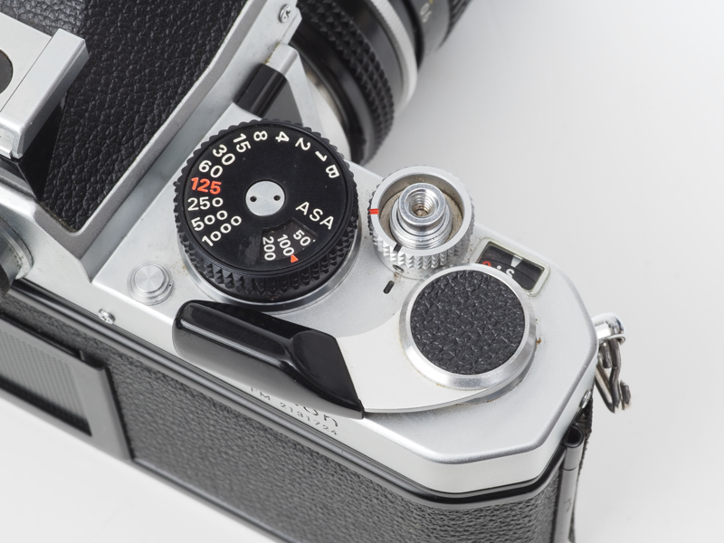 ニコンFMのボディ上部です。シャッターダイヤルがフツーの一眼レフと同じ位置になりました。最高シャッター速度1/1,000秒、シンクロ速度1/125秒。ニコマートFT3と仕様は同じです。フィルム巻き上げレバー上部の円形の張り革はNew FM2まで踏襲されますが、FM3Aからは採用されませんでした。ムダだと思われたのでしょうか。