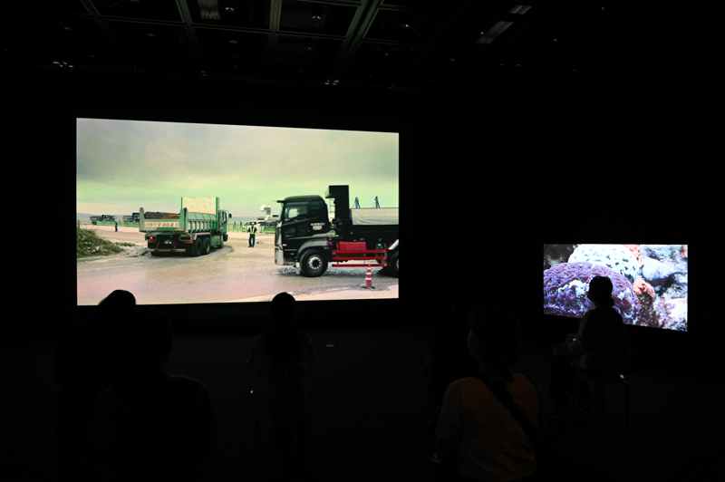 《リフレーミング》展示室。正面の大スクリーンの両脇に小スクリーンが設置。3面でそれぞれ異なる映像が上映されている