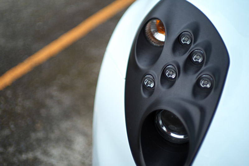 硬質なものを絞り開放で撮影するとどうなるかということで、クルマのライトを至近距離で撮影してみましたが合焦点のシャープネスはなかなかのものです。でも背景のアスファルトやラインの凸凹が奇妙に再現されました。<br>ライカM10-P　HELIAR classic 50mm F1.5 VM（F1.5・1/4,000秒）ISO 100