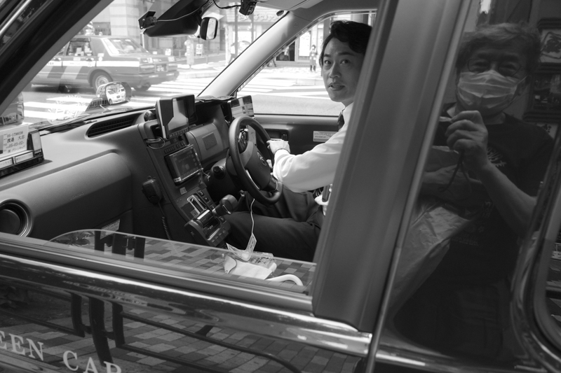 タクシーに乗車したときには、必ずといっていいほどに車内で会話を楽しんでいる。この男性も役者の経験があったそうだ。元ミュージシャンなど、ここから生まれた出会いも数多いという<br><span class="fnt-85">RIOCH GR III／28mm／プログラムAE（F3.5、1/200秒、－1.0EV）／ISO 200／オートWB／モノトーン</span>