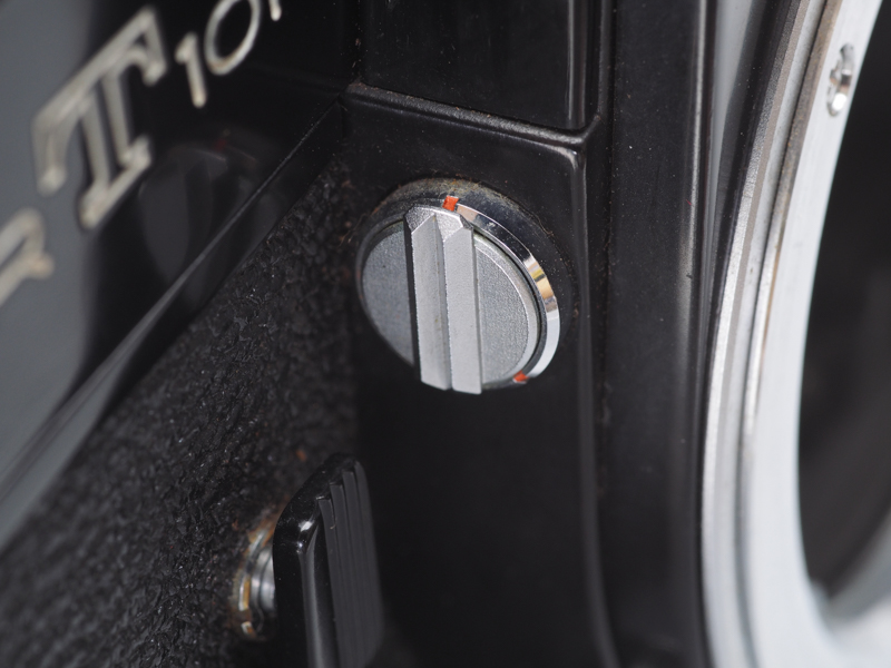 マウント部の脇にあるのがミラーアップレバーです。初期から中期までは存在していましたが、途中で省略されてしまいました。その理由はミラーアップして使用する広角レンズがなくなったからです。撮影時に少しでもショックやシャッター音を小さくするにはミラーアップした方がいいのですが、このあたりの考慮はないですね。