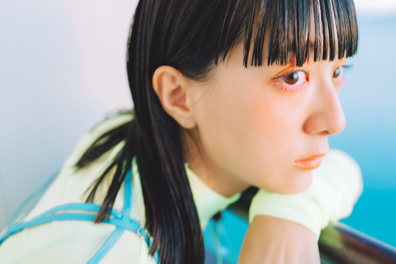 海辺のバルコニーで夕日を眺めながら撮影した。瞳に映る夕日がきれいに表現できたのはマクロ性能のおかげ。海の色がワンピースと同じ鮮やかなブルーだったので、海も入るような構図で撮影した<br>EOS R5／RF35mm F1.8 MACRO IS STM／35mm／絞り優先AE（F2.8、1/30秒、＋1.7EV）／ISO 200