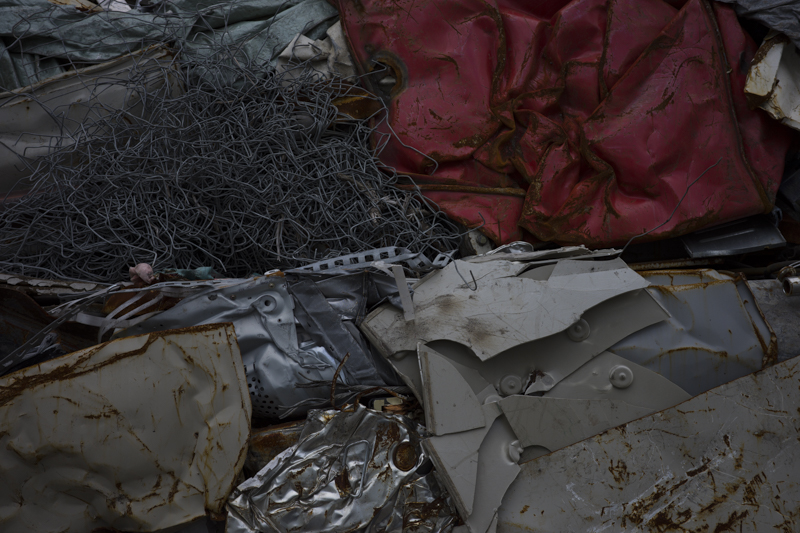 1つの役目を終えたものたちがプレスで圧縮。ここからシュレッダーで細かく分解され、再び次の商品となる。その生まれ変わり（リサイクル）の途中<br><span class="fnt-85">RICOH GR IIIx／40mm／プログラムAE（F5、1/400秒、－1.3EV）／ISO 100／WB：太陽光</span>