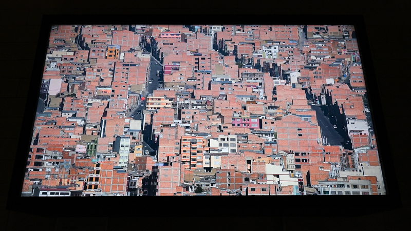 上の展示室とは別の映像作品。密集する建築の中で、車の動きなどが確認できる