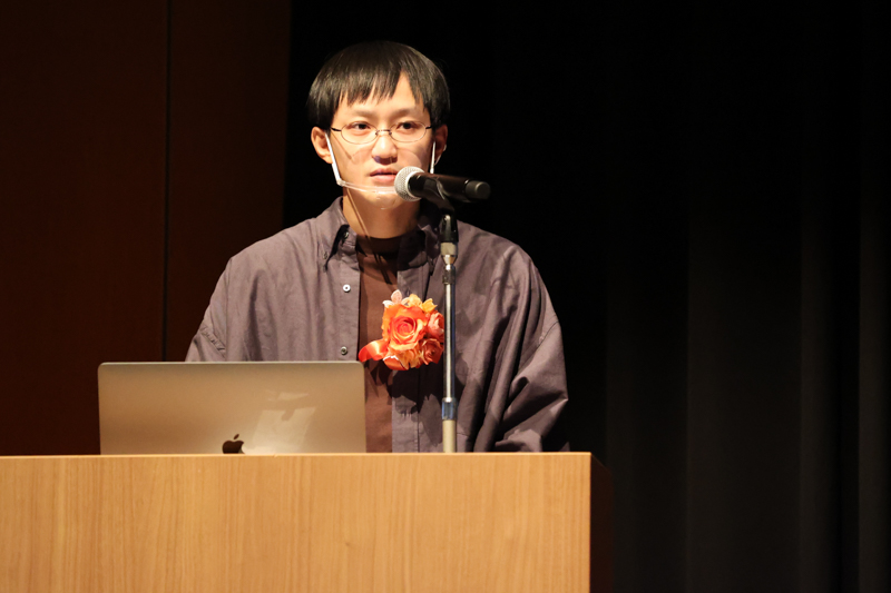 壇上でプレゼンをする賀来さん