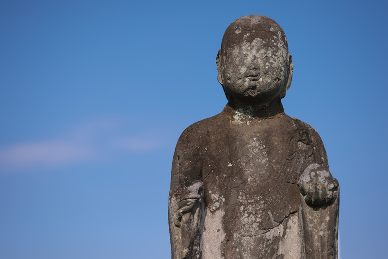 トシをとると、寺とかお地蔵さんとか仏像とかが気になる被写体になるのはなぜでしょう。あちら方向への距離が縮まってきたからでしょうか。青空バックの気持ちよさを出したかったのですがディテールの再現がすごくて顔が気持ち悪いですね。<br>ニコンDf　APO-SKOPAR 90mm F2.8 SLIIs（F4・1/1,600秒）ISO 100