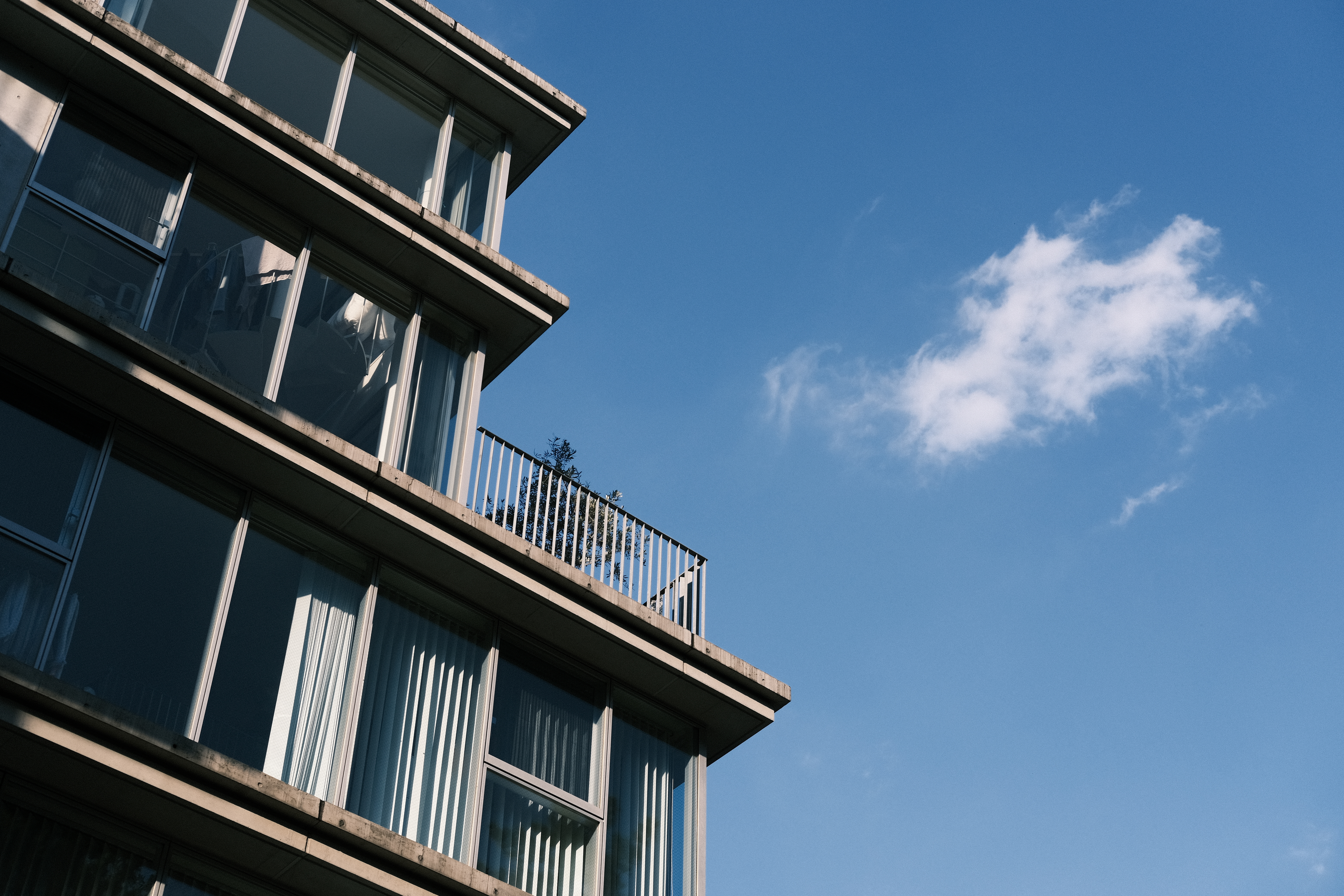 空を見上げたら雲が流れてくるのを見つけた。空の青を強調するために、カラークローム・ブルーを強に設定。動く雲と建物とのバランスと意識しながらシャッターを切った。<br>X-E4　XF35mm F2 R WR（絞りF5.6）ISO 160