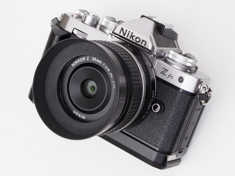 Z fcには純正グリップをつけて、NIKKOR Z 28mm f/2.8 Special Editionを装着して、Ai AFニッコール28mm f/2.8D用のHN-2フードを装着。それなりに全体の印象は変わりますよね。
