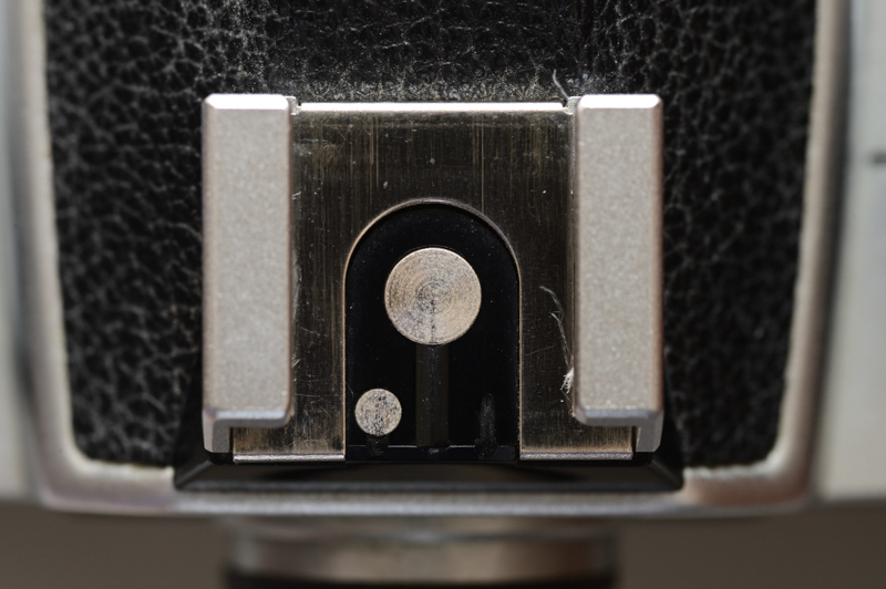 写真6：ニコンのアクセサリーシュー接点の変遷。これはニコンFEのもの。追加の接点は1個のみで、ファインダー内のレディライト表示やシンクロ速度の設定に使われている。