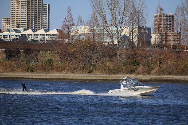 河川敷を歩いているところで偶然出会った水上スキーの練習風景ですが、これはスポーツ写真ではなく「都市風景」です。何もお願いしていないのに、EOS R3は勝手にボートや水上スキーをしている人を捕捉します。<br>EOS R3　RF70-200mm F4 L IS USM（F5.6・1/5,000秒）ISO 400