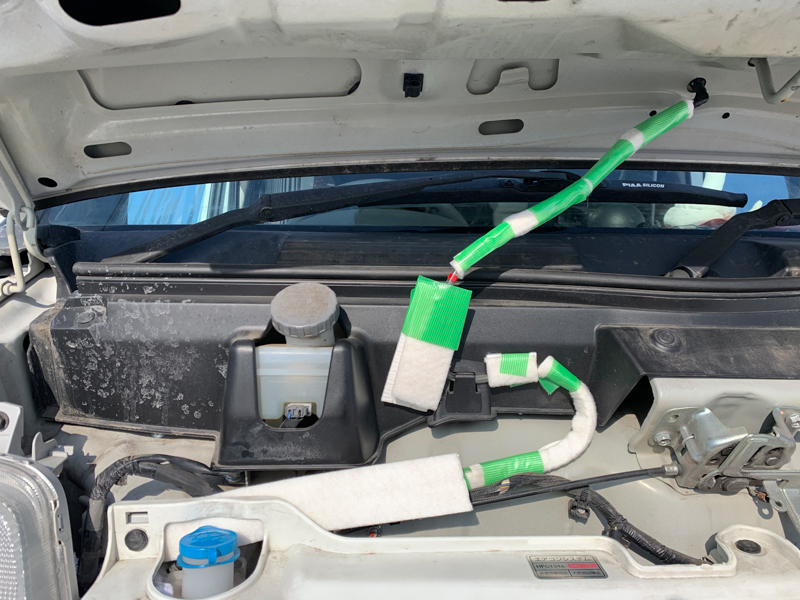 取材車のウォッシャー液ホースに施した、凍結防止対策。