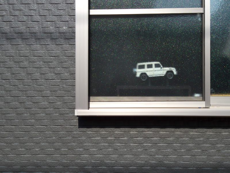 路地を歩いていると、窓ガラスの中にもこうしたドラマを見つけることがあります。ポケットからカメラ引っ張り出してサクっと撮影しました。画角的には肉眼で見つめている感じです。<br>Q-S1　01 STANDARD PRIME（F5.6・1/1,250秒）ISO 400