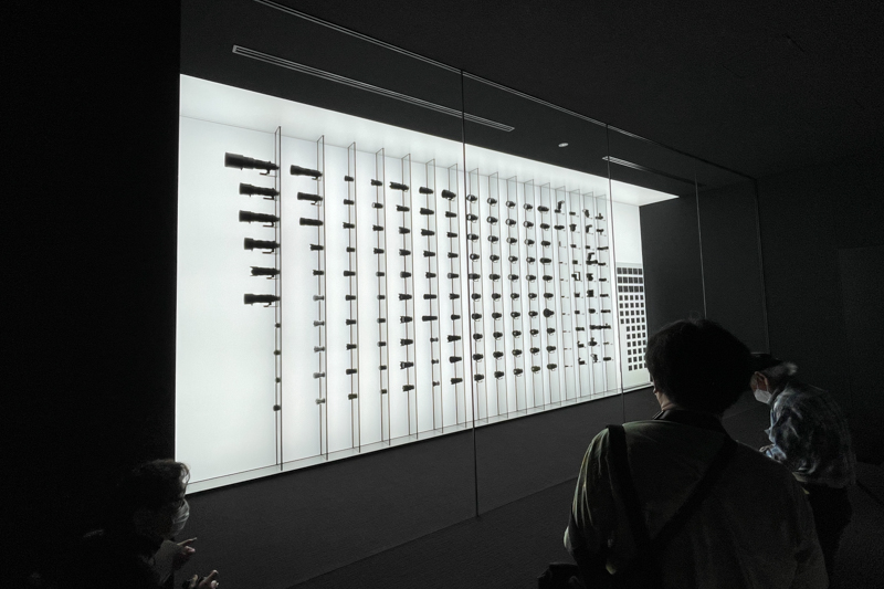 レンズセラーの内部。黒一色の箱のような空間に、画素に見立てた製品が浮かび上がる。天井の高さは4m