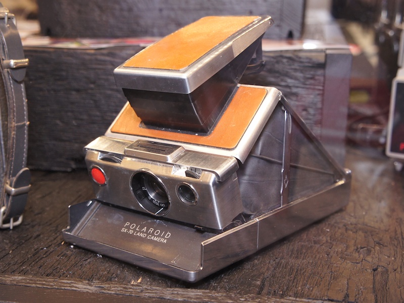 インスタントカメラは大型化しがちなので、折り畳み形式、それもユニークものが多い。これはポラロイドSX-70で、携行時には四角い板のような形状だが、屋根のような部分を引っ張り上げことにより、こんな形になって撮影態勢に入る。